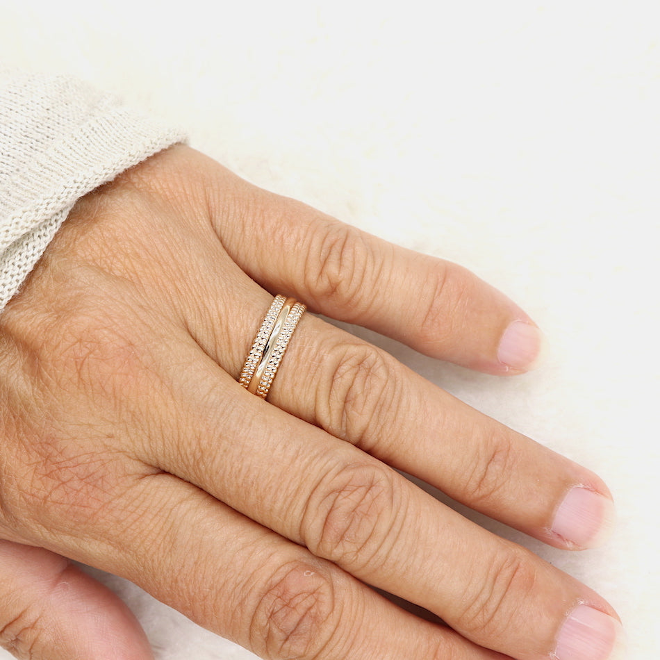 on peut voir une bague en plaqué or pour femme avec des dessins de perles