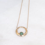 il y a un collier anneau en plaqué or pour femme associé à une pierre de gemmes ronde semi précieuse aventurine