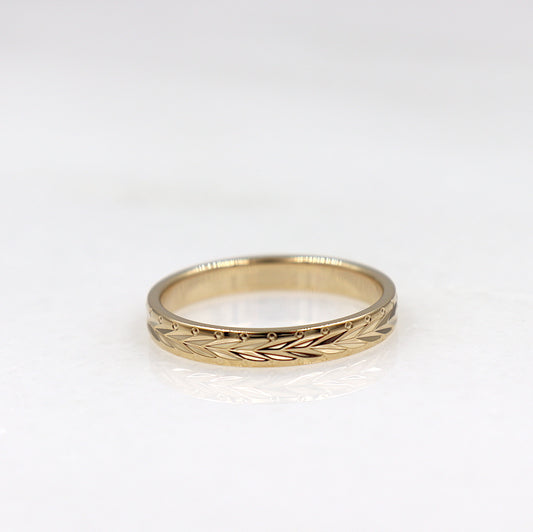 il y a une bague pour femme en plaqué or avec des motifs ciselés feuille de laurier