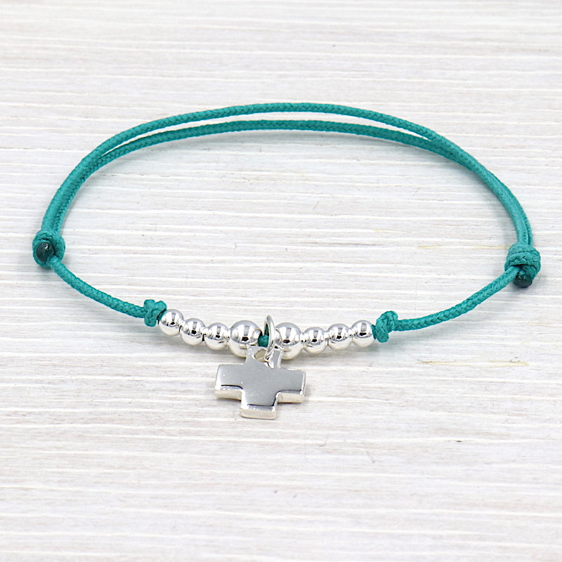bracelet fait avec un cordon associé à une croix et des perles en argent 925