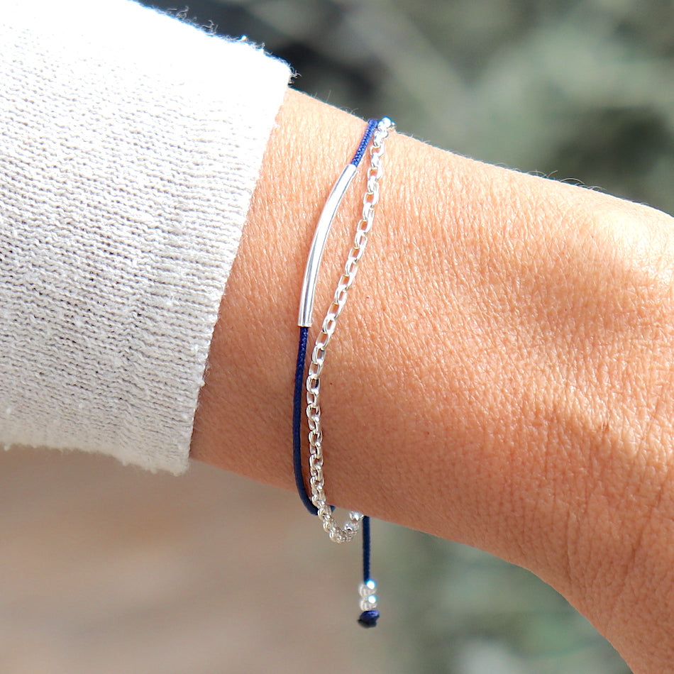 on peut voir un bracelet femme réalisé avec un cordon couleur personnalisable associé à une chaine forme rollot avec un jonc en argent 925 présenté sur un poignet