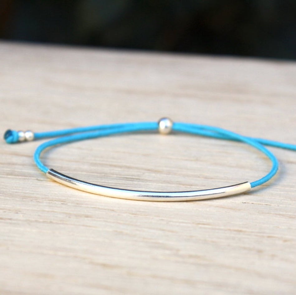 il y a un bracelet cordon couleur personnalisable associé à un jonc en argent 925 et des perles