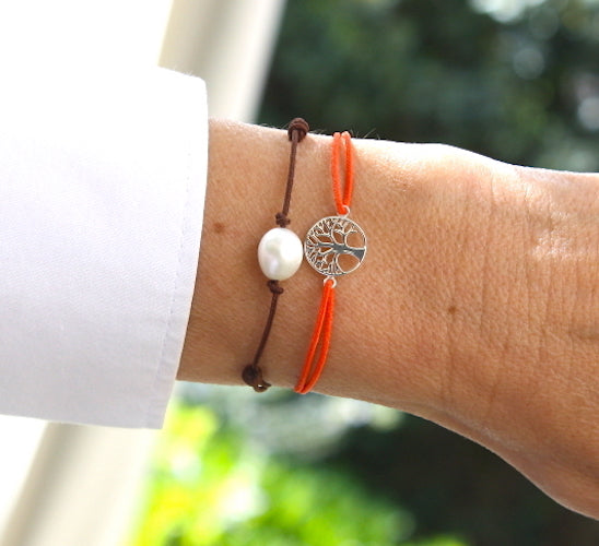 deux bracelets cordons pour femme constitués d'un arbre de vie argent et d'une perle d'eau douce présentés sur un poignet à retrouver sur unbijouforyou.fr
