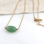 il y a un collier avec une pierre de gemmes aventurine ovale  montée sur une chaine en plaquée or