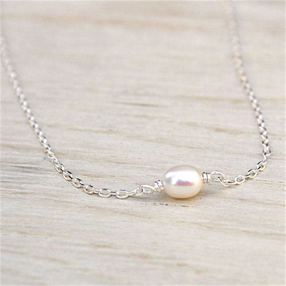 il y a un collier pour femme avec une perle d'au douce montée sur une chaine en argent 925