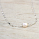 il y a un collier pour femme avec une perle d'au douce montée sur une chaine en argent 925