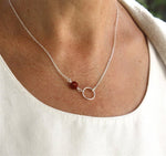 il y a un collier anneau sur chaine en argent associé à un carré en pierre de gemmes couleur personnalisable pour femme