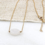 il y a un collier plaqué or pour femme avec une pierre de lune ovale sur chaine